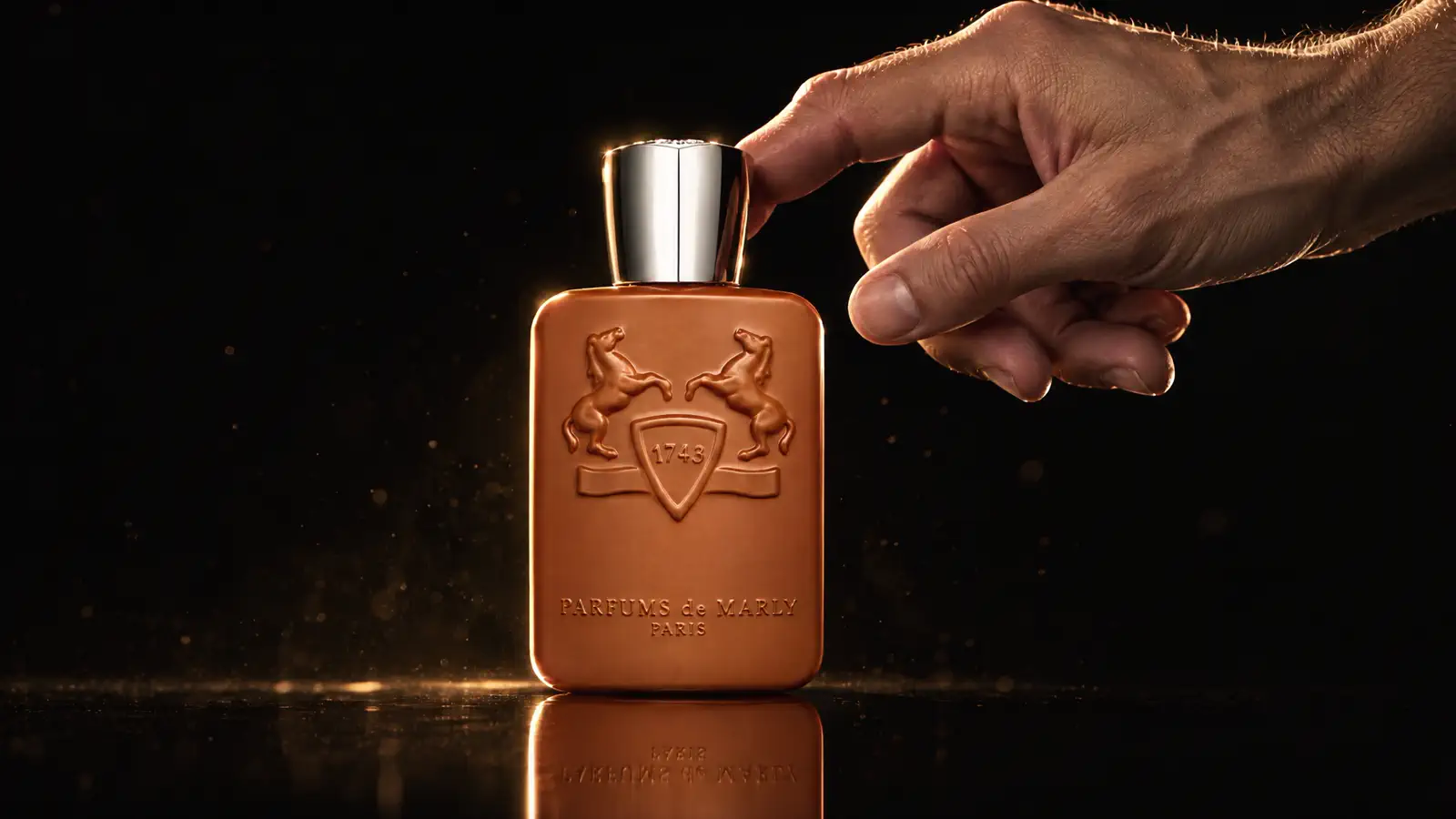 Флакон Parfums de Marly Althaïr на чёрном фоне, рука тянется к крышке